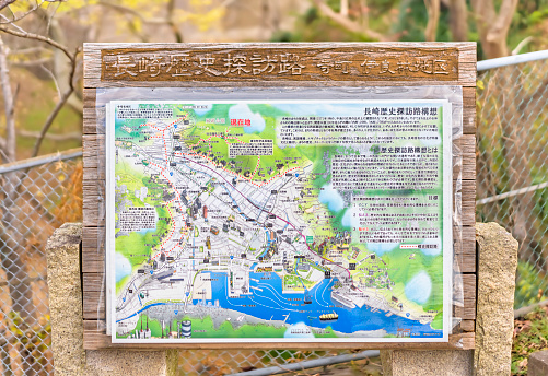nagasaki, kyushu - december 14 2021: Close up on an information and map wooden panel depicting the Nagasaki history sight-seeing road plan in the Kazagashira park.