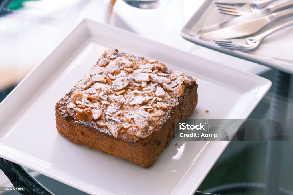 selective focus, Bostock with the addition of almond cream (frangipane) made of baked brioche slices, close up view. Traditional french sweet toast, French patisserie almond toast Brioche Stock Photo