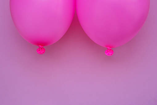 Breast cancer concept without people. Pink balloons on pink background. Studio shoot.