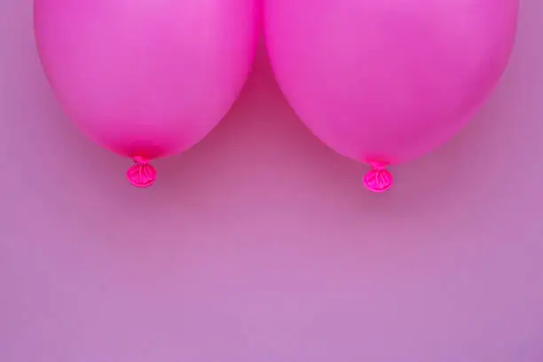 Breast cancer concept without people. Pink balloons on pink background. Studio shoot.