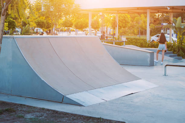 ramps and halfpipe eqipment and trampolines at the modern urban extreme skate park during sunset time. city sports spaces for teenagers and youth - bmx cycling bicycle street jumping imagens e fotografias de stock
