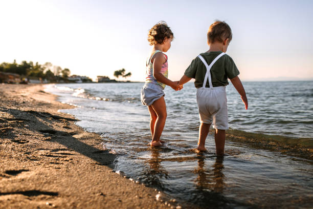 Brother and sister playing in the water on the beach