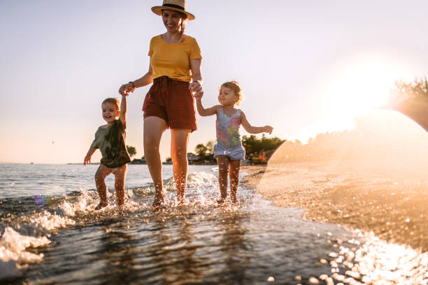 istock Mother and her toddlers having fun at beach 1427707410