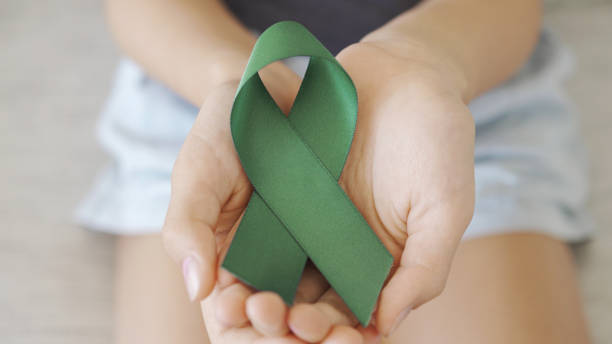 hands holding Green Ribbon, World Mental Health Day stock photo