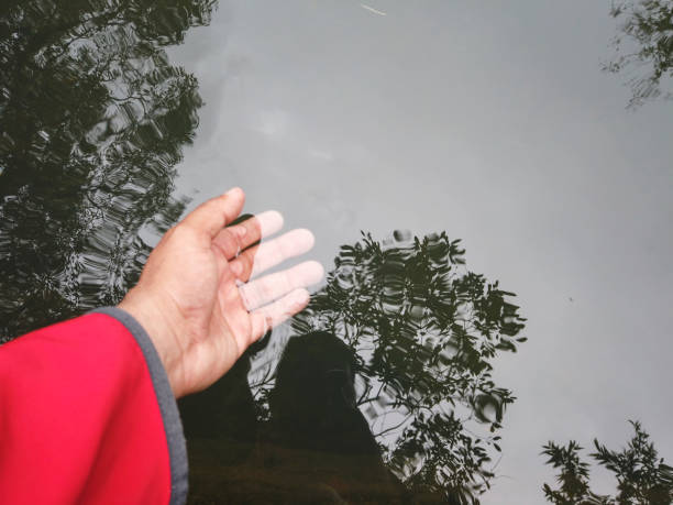 Male hand touching the water