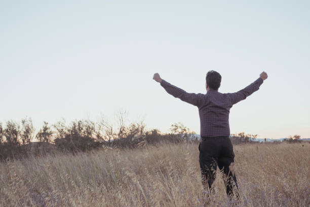 istock Man raising his arms in the field 1427709499