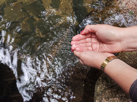 Female hands touching the water
