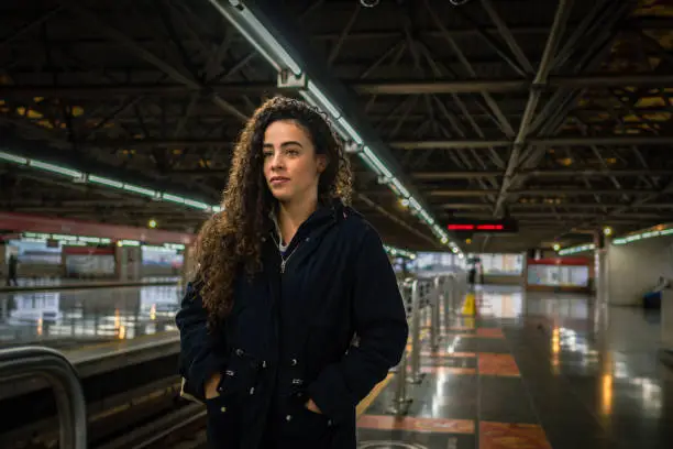 A serious looking woman waiting for the subway