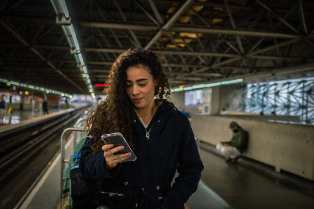 istock A woman using her cell phone at the subway station 1427713094