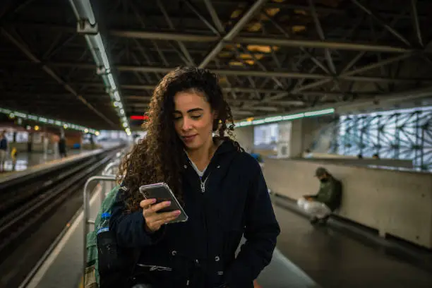 A woman using her cell phone at the subway station