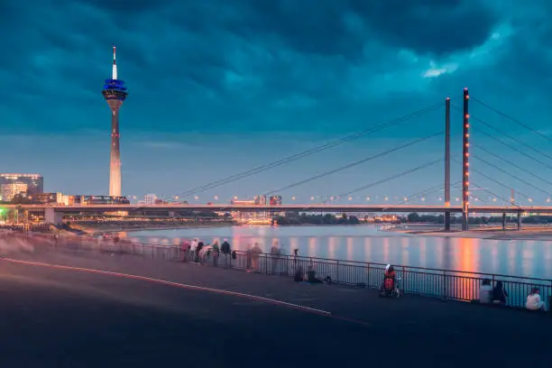 Rheinturm Tv Tower - is a famous travel and sightseeing landmark with bridge over Rhine River at night with majestic illumination