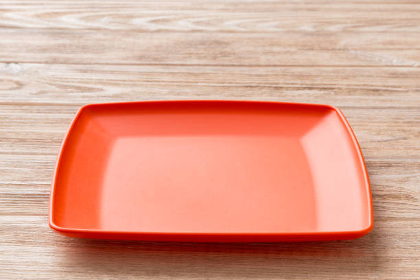 istock Perspective view of empty square plate on wooden background. Empty space for your design 1427718083