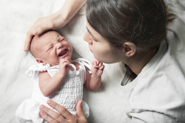 Newborn crying, sleep of children. Tired Mother with Upset Baby Suffering with Post Natal Depression Newborn crying, sleep of children. Tired Mother with Upset Baby Suffering with Post Natal Depression. sleep issues in babies stock pictures, royalty-free photos & images