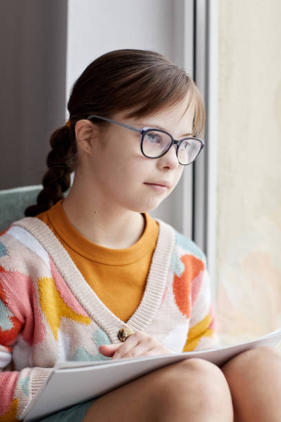 istock Girl With Down Syndrome By Window 1427750337