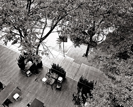 A black and white overhead perspective on a quiet bistro on an urban side street.