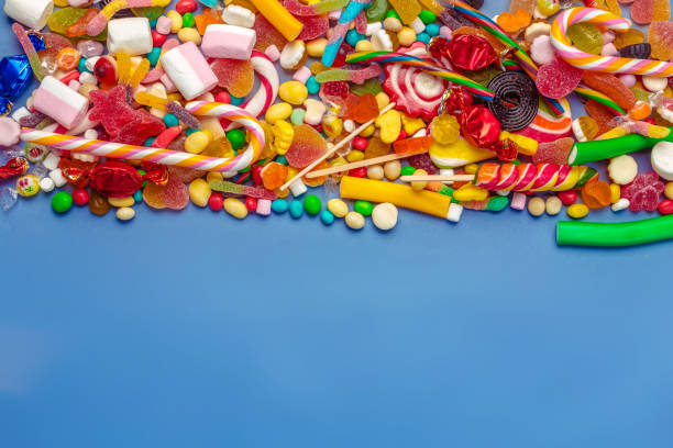 istock Colorful candies on table on blue background 1427796663