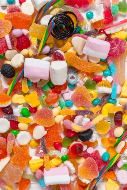 istock Colorful candies on wooden background 1427796847