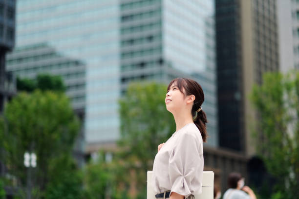 Confident businesswoman and office building