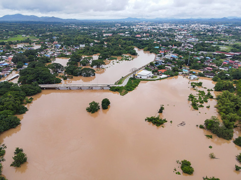 Aerial view river flood village countryside Asia and forest tree, Top view river with water flood from above, Raging river running down jungles lake flowing wild water after the rain