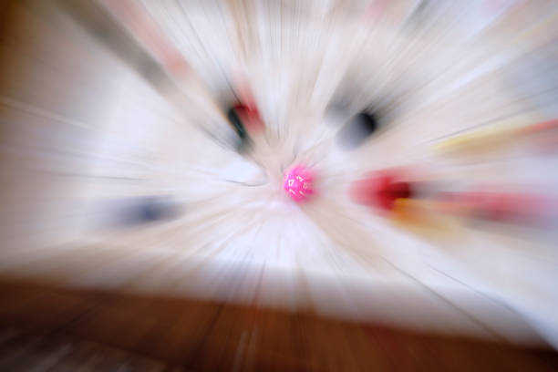 Optical zoom technique, blurred motion zoom centering on the pink 20 sided dice (d20) on a role paying game table with map, papers and other role play game pieces. The d20 is the most common dice used in role playing games.