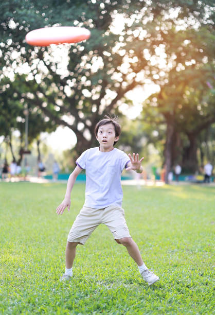 Little boy plays frisbee in park