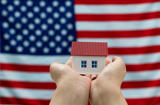 Model house in front of American flag.
