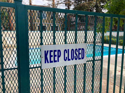 Keep Closed warning sign on the entrance gate to the outdoor pool to remind people to keep the swimming pool gate closed at all times