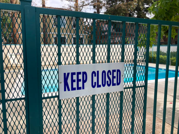 Keep Closed warning sign on the entrance gate to the outdoor pool to remind people to keep the swimming pool gate closed at all times. Keep Closed warning sign on the entrance gate to the outdoor pool to remind people to keep the swimming pool gate closed at all times pool gate stock pictures, royalty-free photos & images