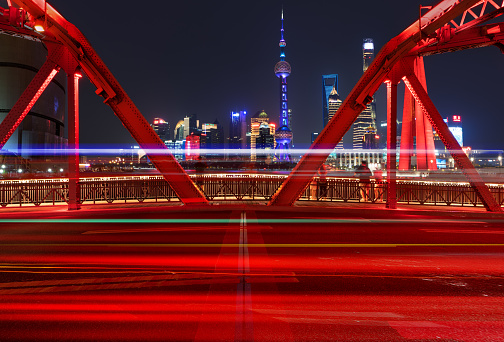 a famous bridge of The Bund in Shanghai at night, and beautiful light trail at highway,