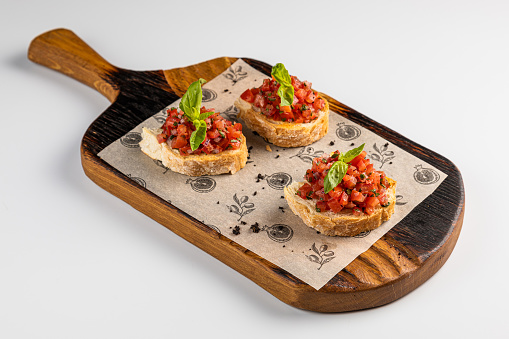 Tasty savory tomato Italian appetizers, or bruschetta with Herbs Isolated, chopped vegetables