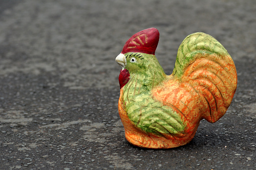 Colorful chicken piggy bank on asphalt