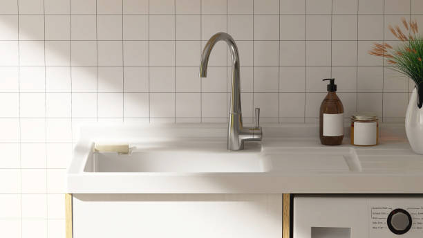 istock Modern and minimal quartz sink counter with cabinet and white tile wall in sunlight from window 1427834658