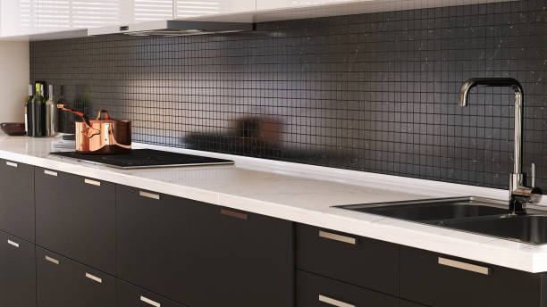 istock Minimal and luxury black kitchen counter with white marble top and stainless sink with sunlight from window on mosaic wall 1427834853