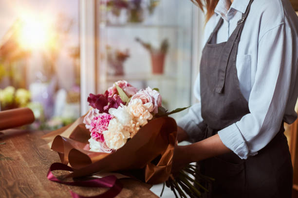 istock Florist wrapping fresh bouquet with paper 1427845763