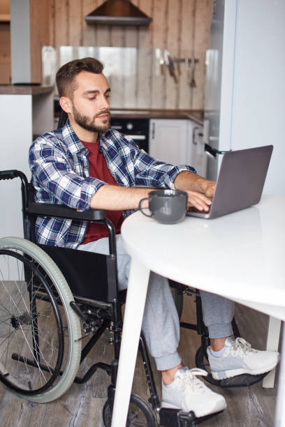 istock Handicapped man working on laptop from home 1427846655
