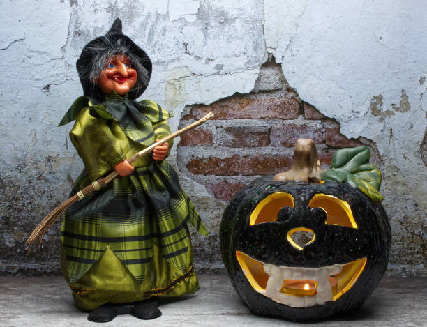 Halloween Witch in decorated dress holding a wooden broom. Trick or treat. Happy Halloween. stock photo