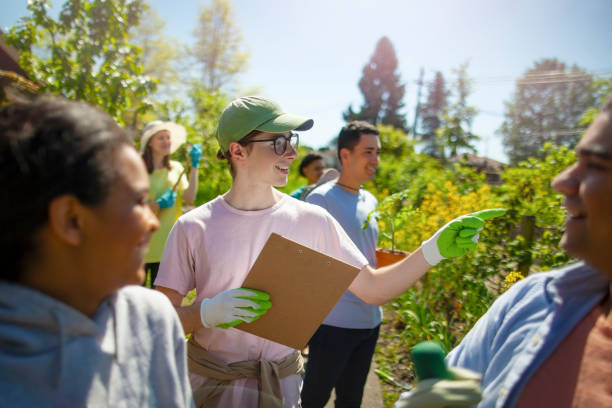 istock Young man student coordinates as manager leader the cleanup work for youth organization volunteer charity in local community garden public park in residential district in summer 1427853030