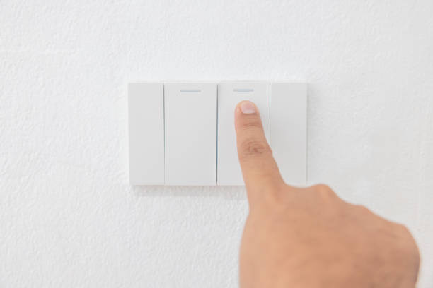 istock Close-up light switch of a male finger will turn on or off a light switch with white wall at home. white plastic mechanical switch mounted. Energy, energy, save electricity, copy space 1427861204