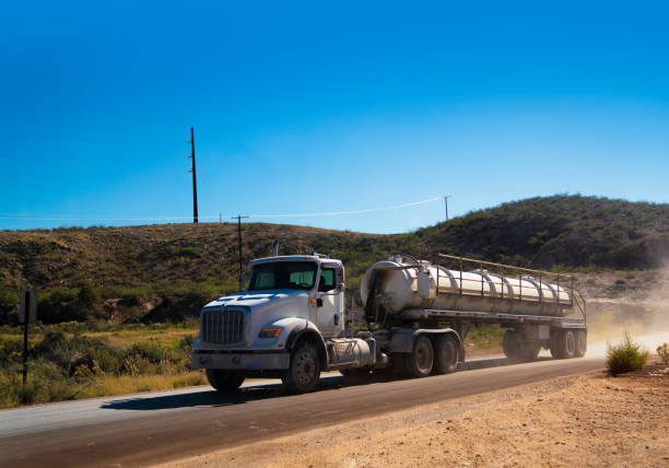 semi truck transporting chemicals driving on a dirt road - oil industry industry new mexico oil drill imagens e fotografias de stock