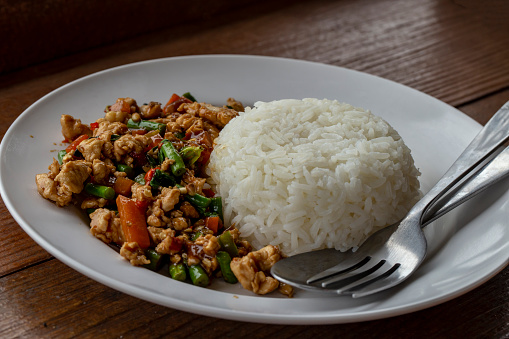 Rice and Stir fried Thai basil with chicken on white plate