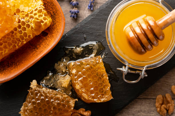 istock Honeycomb on slate tray with honey and nuts on kitchen table 1427870027