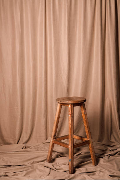 istock Wooden bar stool on a fabric brown background 1427872286