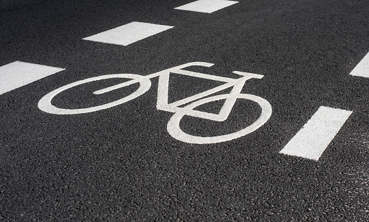 White road markings on tarmac to separate cyclists from cars