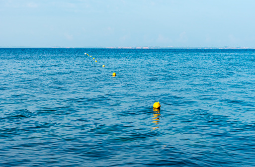 Lined up yellow buoys in the sea