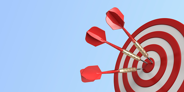 Three darts hitting a red target on the center on blue background with copy space. 3d illustration