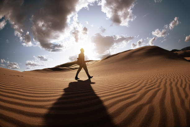 istock Traveler walks at sunset dunes in desert 1427880465
