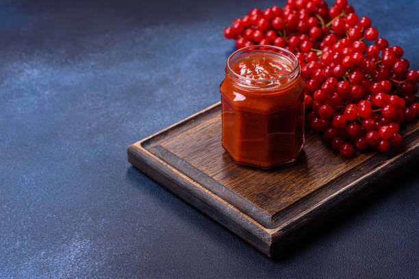 istock Viburnum fruit jam in a glass jar on a dark concrete background 1427882019