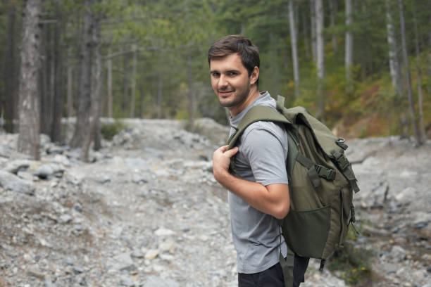 istock Caucasian man walking in the forest wearing a tourist backpack 1427883483