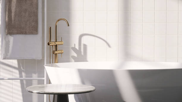 istock Marble top side table by white ceramic bathtub in contemporary design bathroom with sunlight from window on white tile wall 1427889560