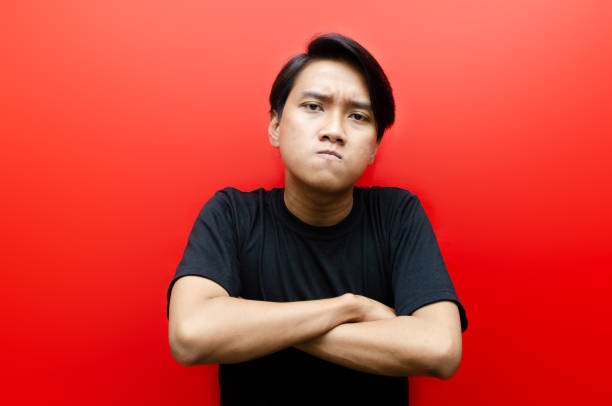 asian man with angry expression threatening and looking for fight.